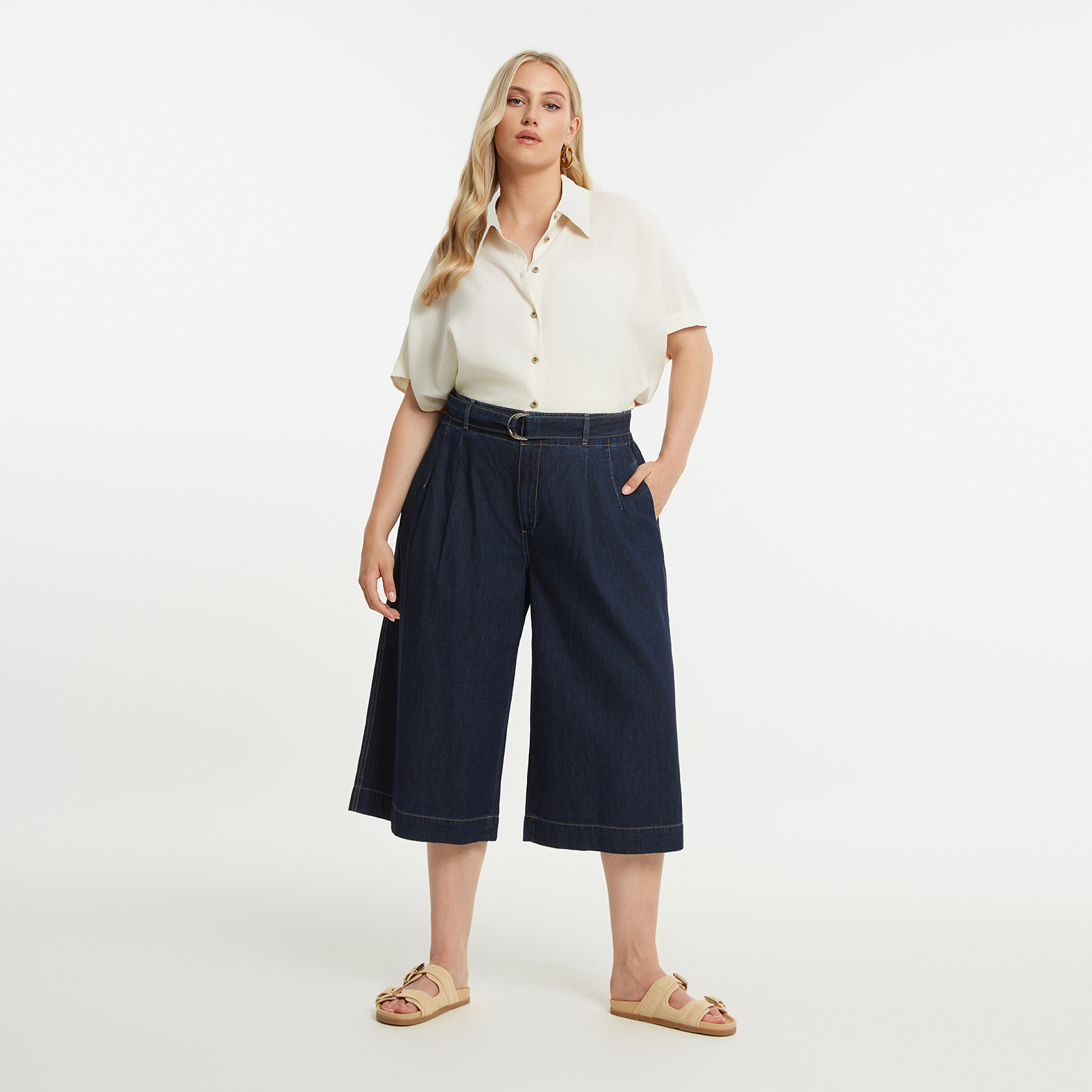 Cropped denim παντελόνα από 100% βαμβάκι, σχεδιασμένο με structured αλλά χαλαρή γραμμή. Διαθέτει πιέτες μπροστά, ζώνη με δέσιμο και μεταλλική αγκράφα, καθώς και cropped μήκος που αναδεικνύει σύγχρονο στυλ με διαχρονική denim αισθητική. ● Cropped wide-leg γραμμή για σύγχρονη σιλουέτα ● Ζώνη με δέσιμο και μεταλλική λεπτομέρεια ● Ελαστική μέση πίσω ● Πιέτες μπροστά για άνεση και φυσική κίνηση ● Πλαϊνές τσέπες με πρακτικό χαρακτήρα ● Συνδυάζεται εύκολα από casual έως πιο refined εμφανίσεις 100%COTTON Το μοντέλο έχει ύψος 1,80 εκ. και φοράει S