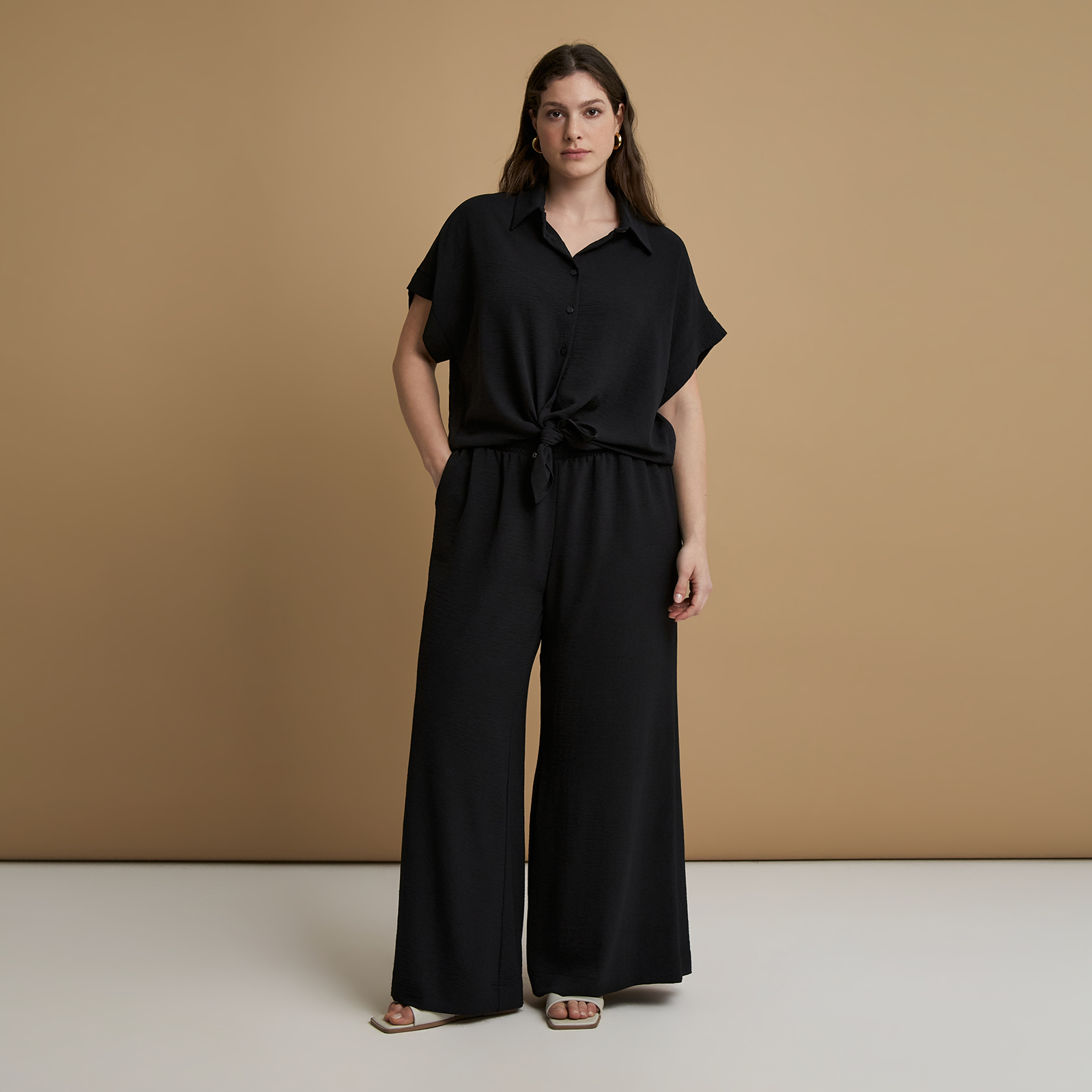 Ένα διαχρονικό κομμάτι για τη σύγχρονη γκαρνταρόμπα. Αυτό το φαρδύ παντελόνι από airwashed κρεπ ξεχωρίζει για τις απαλές πτυχώσεις και την ψηλόμεση γραμμή που κολακεύει και επιμηκύνει το σώμα. Ιδανικό για κομψές εμφανίσεις από το πρωί έως το βράδυ. ● Απαλό ύφασμα airwashed κρεπ με πτυχώσεις ● Ψηλόμεση εφαρμογή που επιμηκύνει τη σιλουέτα ● Φαρδιά cropped γραμμή κιλότ για σύγχρονη άνεση ● Ελαστική μέση στο πίσω μέρος για καλύτερη εφαρμογή ● Μέρος της συλλογής Essentials – ποιοτική αίσθηση για καθημερινή χρήση Μήκος (εσωτερική ραφή): 76,5 εκ. 100%POLYESTER Το μοντέλο έχει ύψος 1,77 εκ. και φοράει S/M