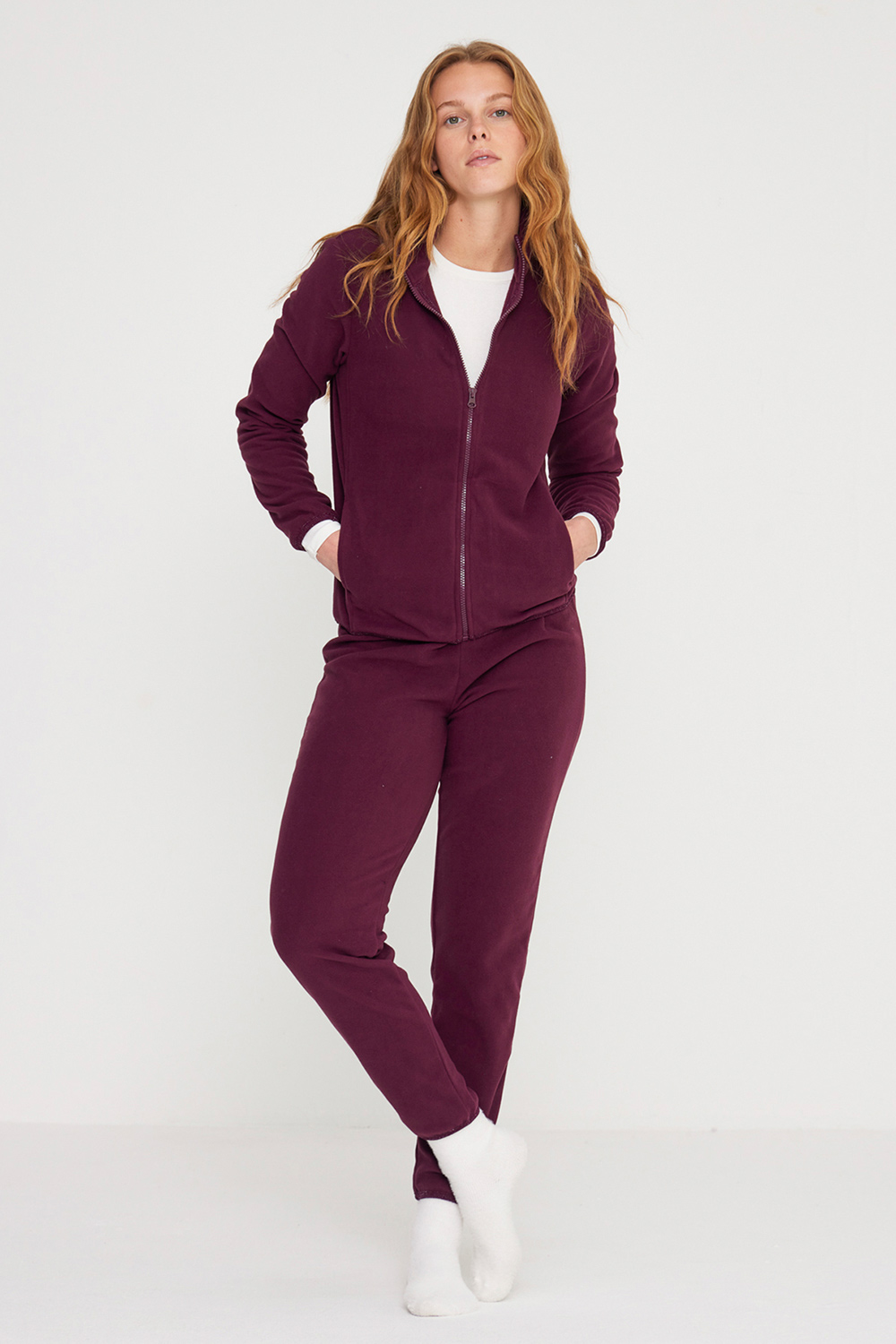 Noidinotte γυναικεία χειμερινή fleece homewear φόρμα πολυτελείας, με φερμουάρ και μπροστινές τσέπες. Το παντελόνι διαθέτει λάστιχο στη μέση για καλύτερη εφαρμογή.Οι μανσέτες, ο ποδόγυρος της ζακέτας και τα μπατζάκια διακοσμούνται με lurex διακριντικό λάστιχο.