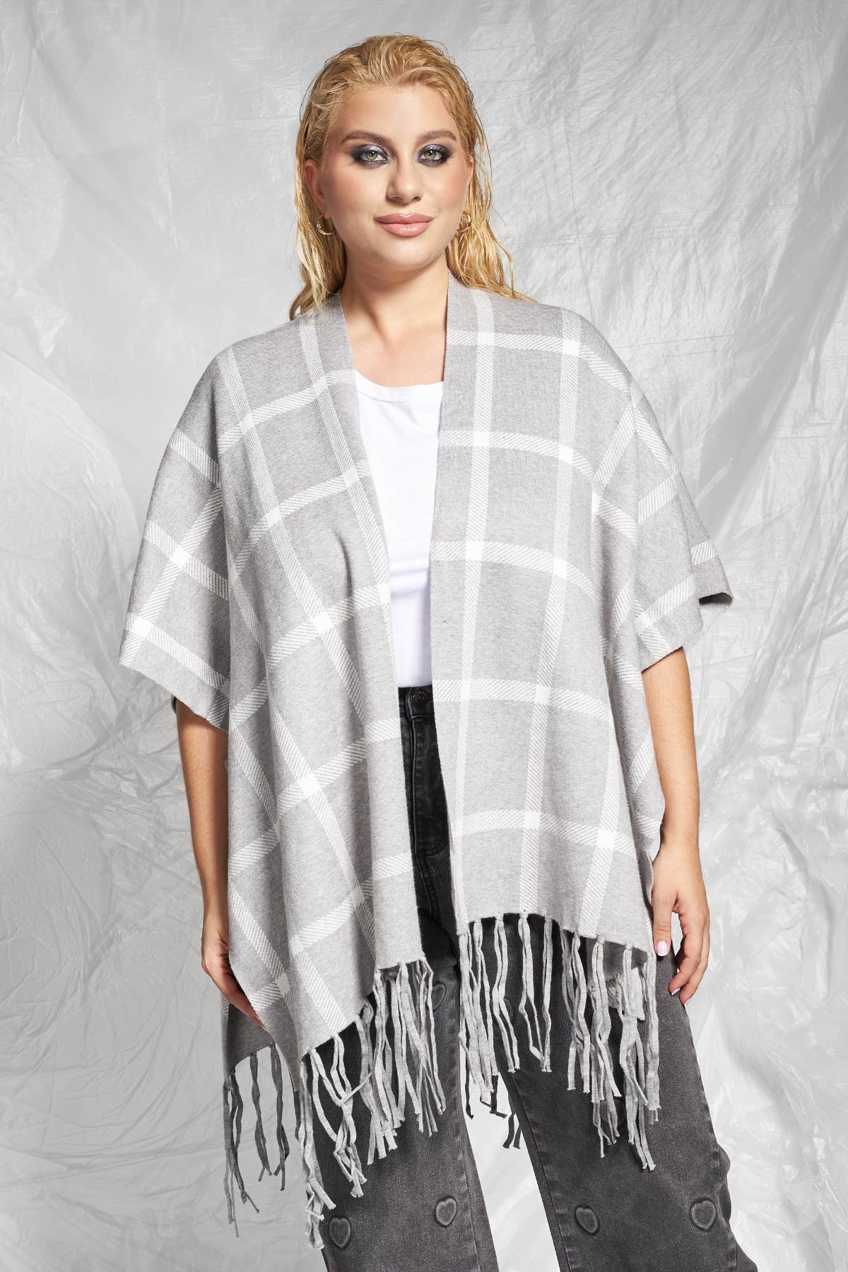 Μια ζεστή και άνετη πλεκτή κάπα με oversized γραμμή που τυλίγεται γύρω από το σώμα, ιδανική για layering. Το κυρίαρχο καρό μοτίβο της αποτελεί μια κλασική επιλογή, ενώ τα μακριά κρόσσια στο τελείωμα προσθέτουν μια boho και παιχνιδιάρικη διάθεση. Λειτουργεί ως ελαφρύ πανωφόρι ή αξεσουάρ, προσφέροντας άμεσο στυλ και έξτρα ζεστασιά. Για ένα casual στυλ, φορέστε την κάπα πάνω από ένα μονόχρωμο ζιβάγκο ή ένα απλό top, συνδυασμένο με ίσια τζιν παντελόνια ή δερμάτινο κολάν. Ολοκληρώστε με flat μπότες ιππασίας ή μποτάκια τύπου Chelsea. Διατίθεται σε 2 μεγέθη. Το μοντέλο έχει ύψος 177εκ στήθος 110 μέση 85 περιφέρεια 115 και φοράει μέγεθος M